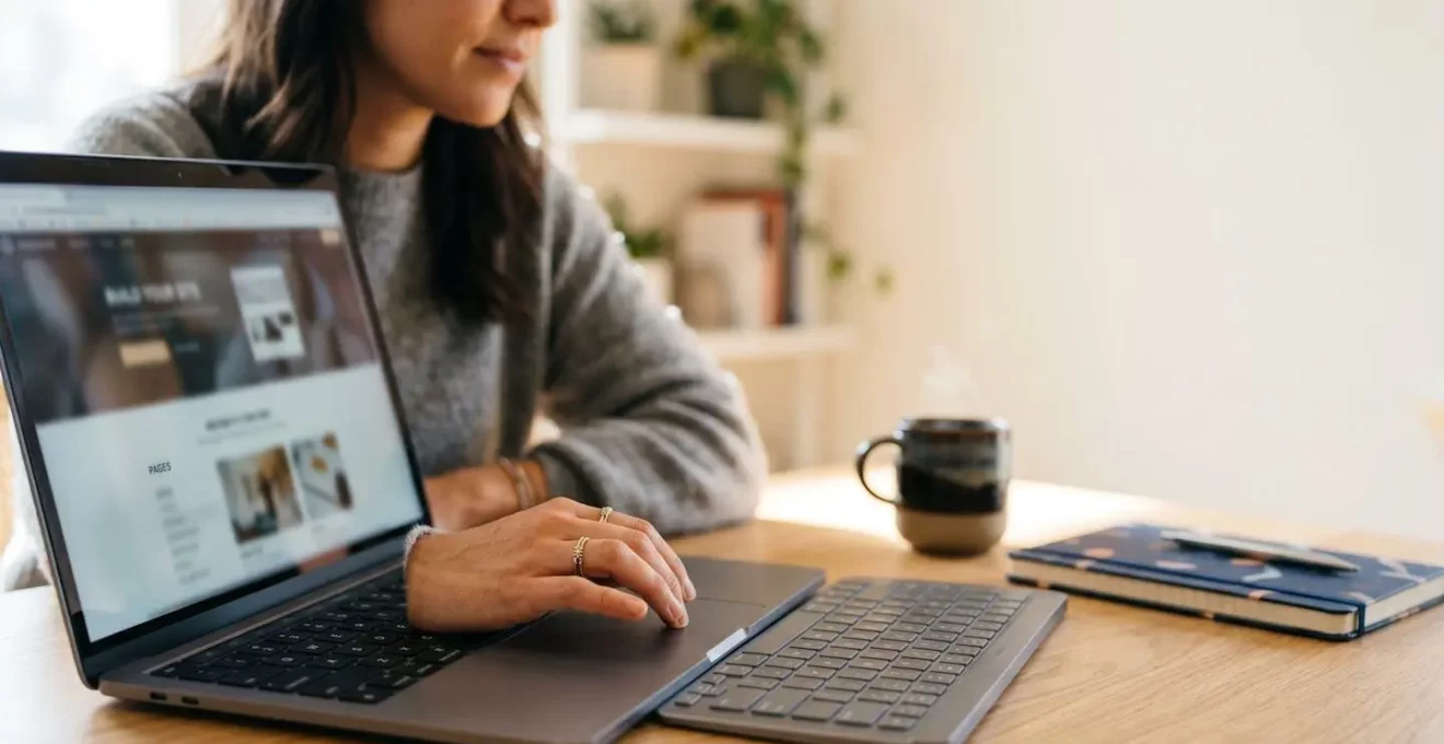 Personne créant un site web professionnel sur ordinateur portable sans compétences en programmation